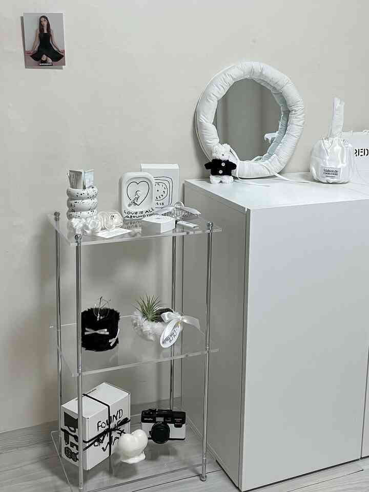 モノトーン調の小さな空間、透明な棚と白い収納棚が配置されたシンプルで清潔感のあるインテリア