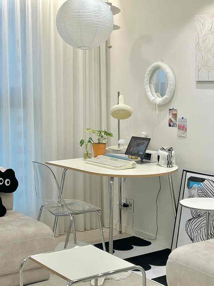 White-tone home office space featuring a transparent chair and Mid-Century Modern style desk in a clean interior