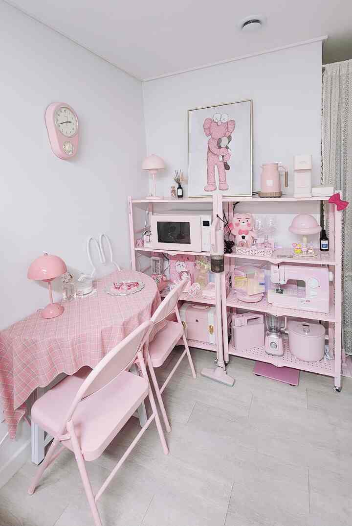 明るいピンク色調のキッチンとダイニングスペース、ピンクの家具と小型家電が調和した雰囲気のあるインテリア