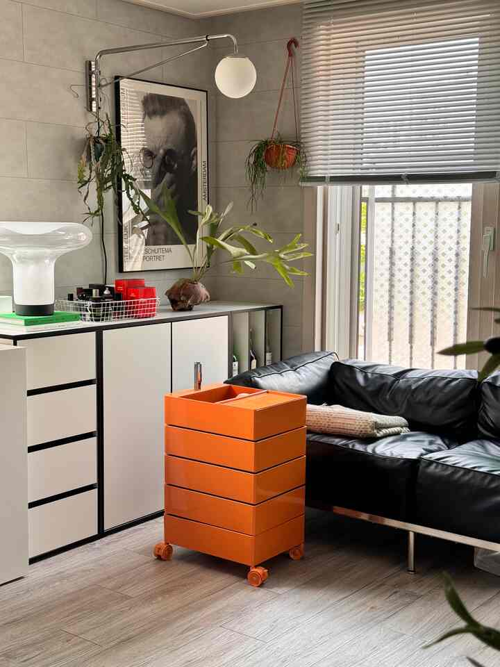 White and black toned living room featuring modern sofa and gap mobile storage cart, with natural and clean atmosphere