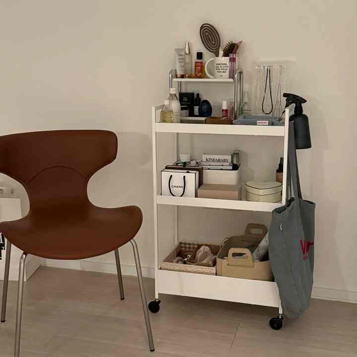 白と茶色のトーンの一人暮らしの空間、イケアのニサフォースカートと椅子が配置されたシンプルで整った収納のあるインテリア