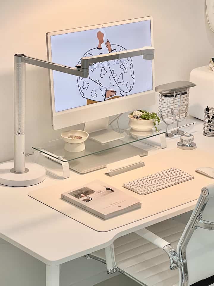 White-toned study featuring an Apple iMac and leather desk pad in a clean and simple desk setting