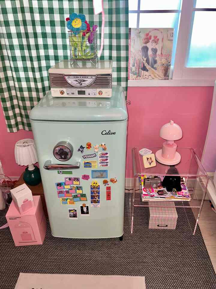 Retro-inspired cozy interior with pink walls, mint refrigerator, and acrylic transparent table