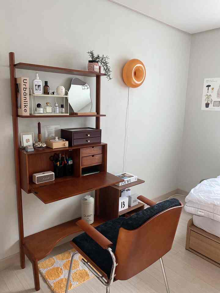 柔らかいホワイトとブラウンの色調の寝室、ミニマルな木製デスクとオフィスチェアが配置された居心地の良い在宅勤務空間