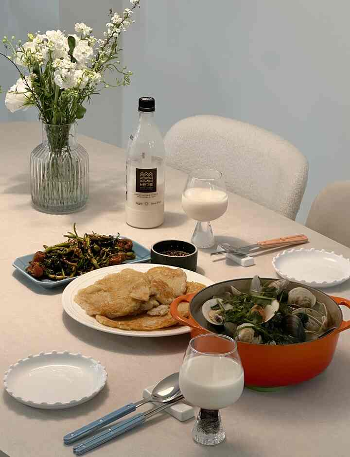 Beige and white toned dining room featuring a vase and traditional Korean dishes, creating a clean and warm atmosphere