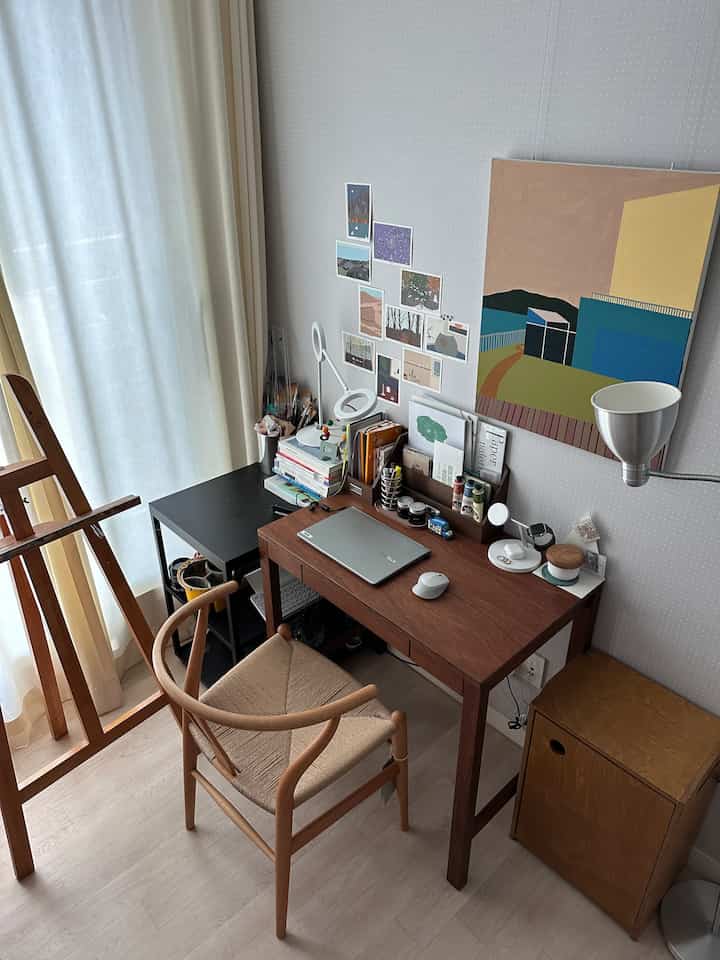 Beige-toned curtains and wood-tone desk with office chair in a compact home office space