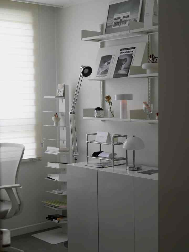 Clean study space in white and gray tones, featuring versatile shelving and lighting with simple, modern atmosphere