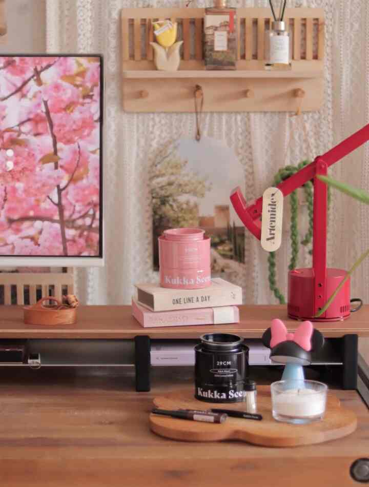 Brown and red toned home office desk space featuring shelves and framed art with cozy atmosphere