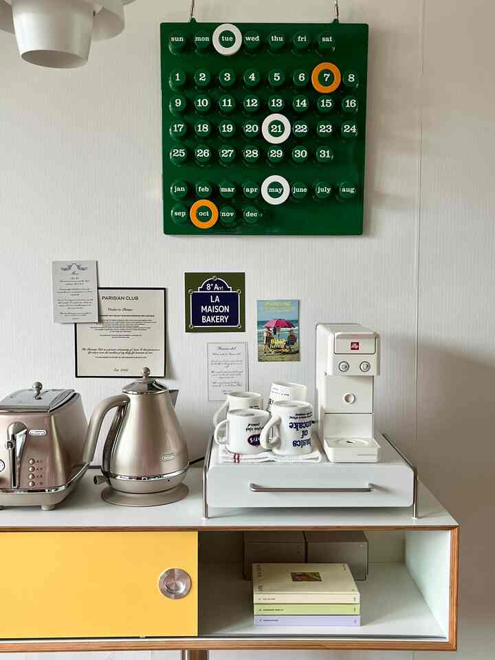 ホワイトとイエローの色調のキッチン、ミッドセンチュリーモダンスタイルのチェストとコーヒーマシンが配置された雰囲気のあるおうちカフェ