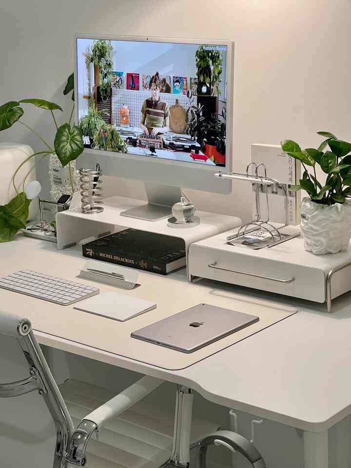 白を基調とした書斎、整ったデスクとモニター台、植物が配置された落ち着いた整理されたインテリア