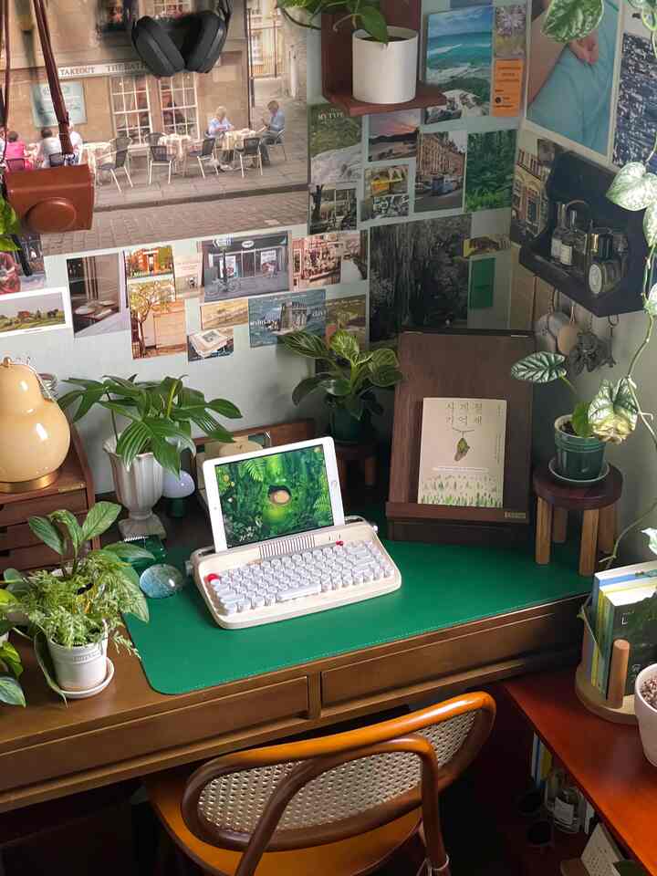 Green and wood tone home office featuring plants and a retro-style keyboard on a desk creating a cozy workspace