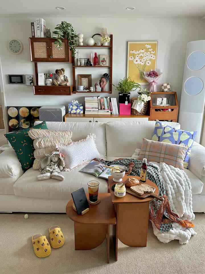 Natural white and wood-toned living room featuring fabric sofa and vintage storage cabinets creating cozy home cafe vibe