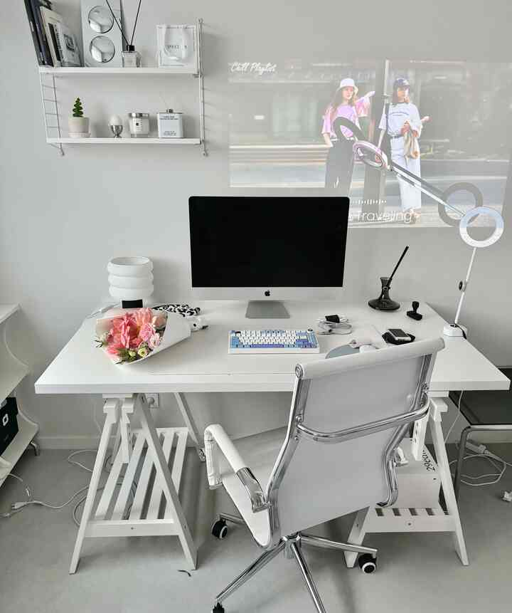 ホワイトとグレーのトーンの書斎、コンピューターデスクとオフィスチェア、テーブルランプとプロジェクターが配置されたシンプルモダンな雰囲気のインテリア