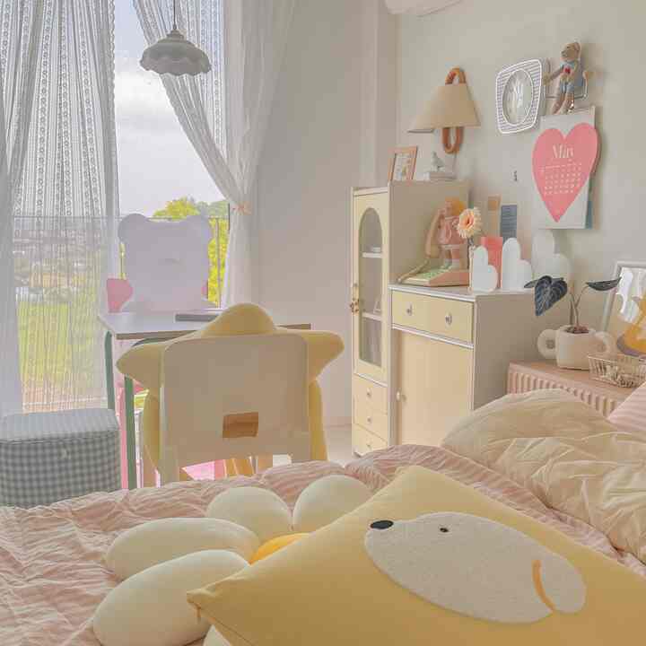 白とパステルイエローの色調の子供部屋、かわいいクッションとベッドが配置された雰囲気のあるインテリア