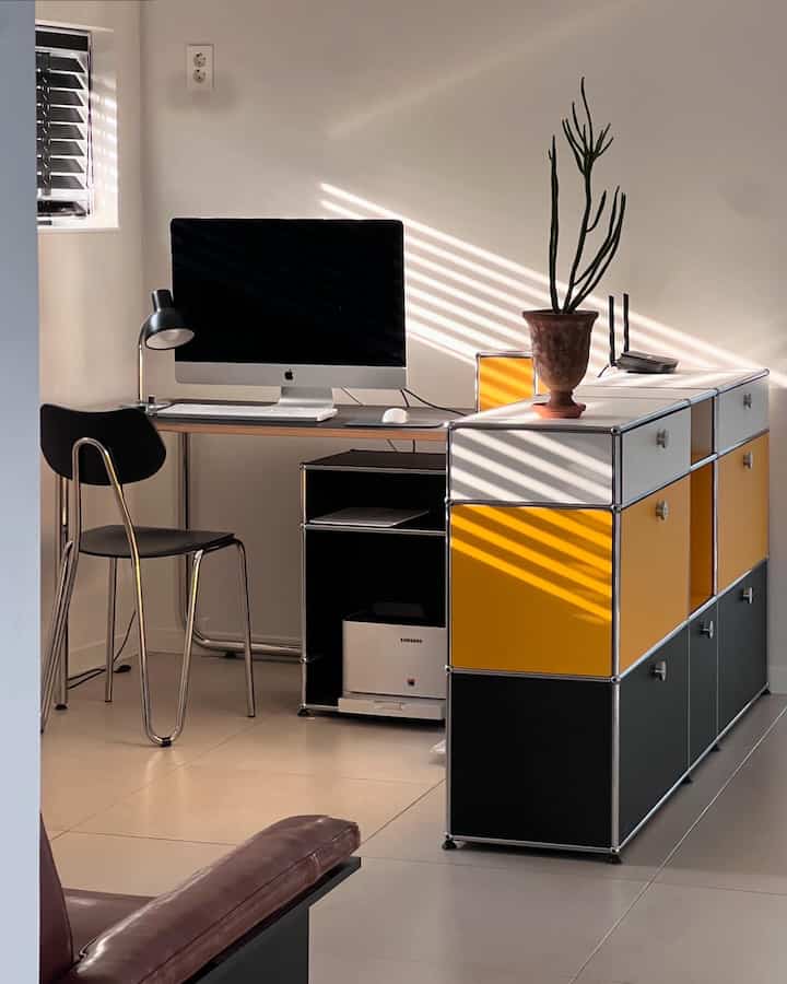 A modern home office with modular furniture featuring bright white, black, and yellow colors in harmony