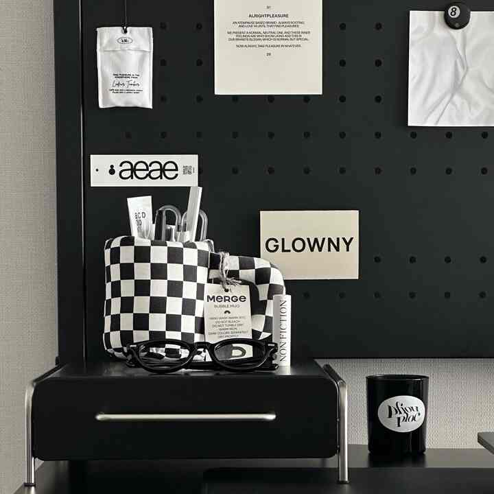 黒と白を基調としたコンパクトな空間、ミニマルなデスクアクセサリーが配置された整然としたインテリア