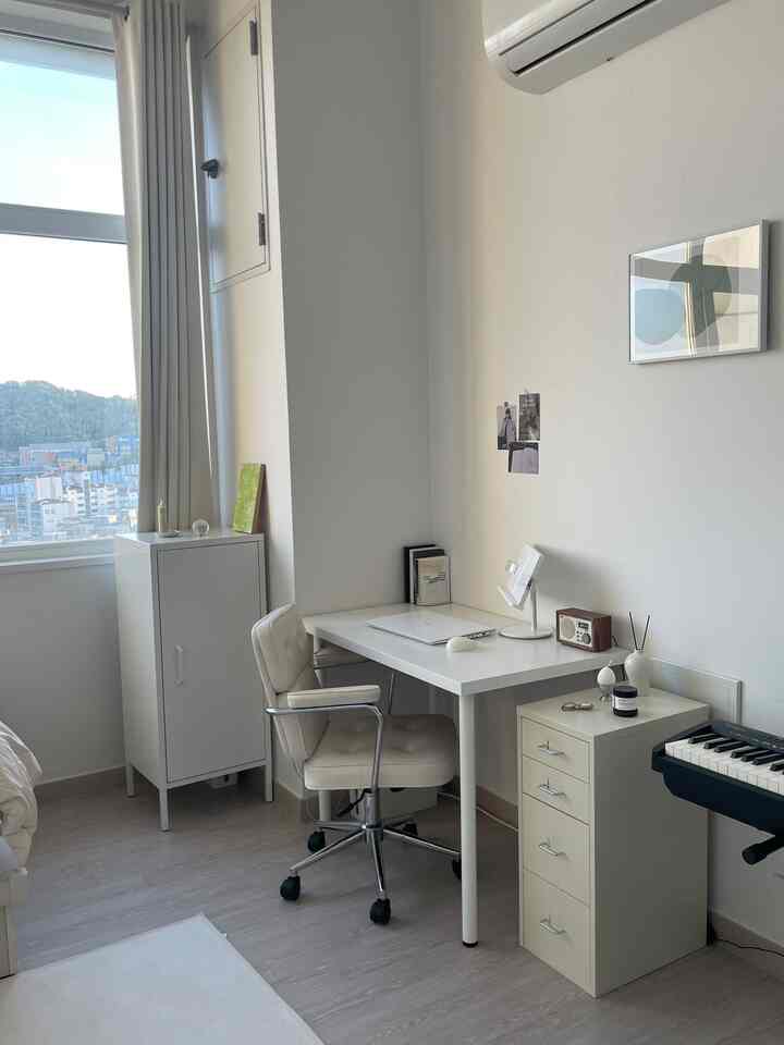 白とベージュのトーンのコンパクトなホームオフィス、机とオフィスチェアが配置された整った作業スペース