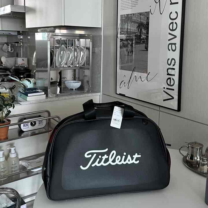 グレーとホワイトのトーンのキッチンにステンレス製の食器とモダンなキッチン用品が配置された、清潔感のあるインテリア