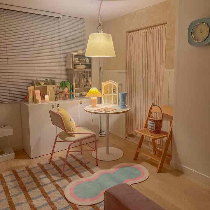 アイボリーとベージュの色調のホームカフェ空間、丸いティーテーブルと複数の照明が配置された雰囲気のあるヴィンテージスタイルのインテリア