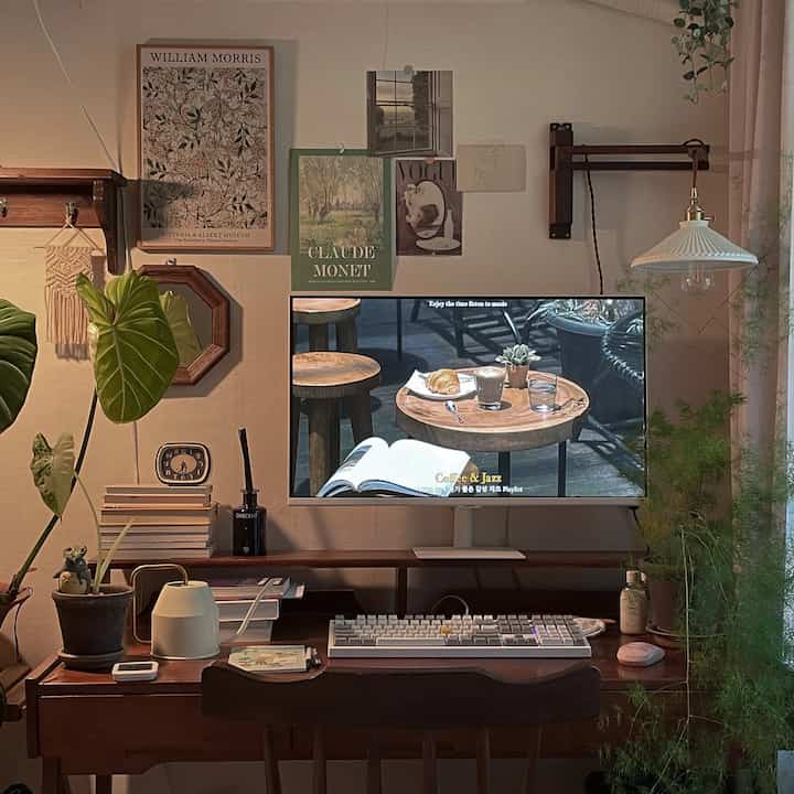 温かみのある木目調と緑の植物が配置された一人用のモダンなホームオフィス印象的な空間