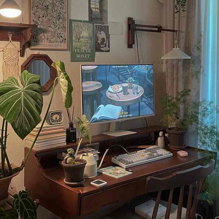 ナチュラルな色調の書斎、木製デスクと多様な植物が配置された落ち着いたホームオフィス