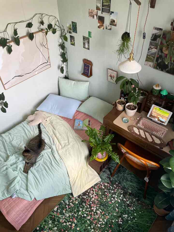 柔らかなナチュラルカラーの小さな寝室、ベッドやデスク、多様な植物が調和した雰囲気のあるインテリア