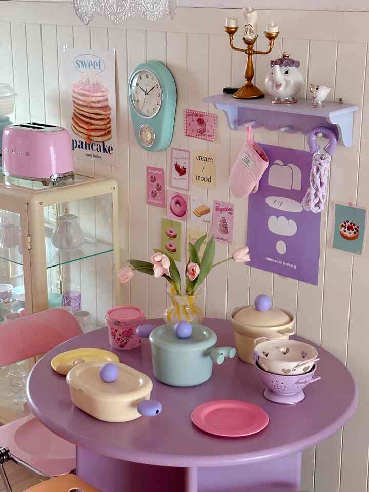 Kitchen space with soft purple and beige tones, featuring pink appliances and vintage clock creating a warm atmosphere