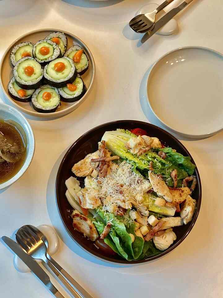 If you like Caesar salad, try it like me👧🏻✨
(Feat. Choi Hwa-jeong's Cucumber Kimbap)

🏷️Ingredients
• 1-1.5 heads of romaine lettuce
• 3 strips of bacon
• 200g of chicken breast
• 3 cherry tomatoes
• (optional) a little crouton, a little Parmesan
• Dressing used: Rewe Beste Wahl 'Parmesan Dressing'

▪️Cut the romaine lettuce crosswise and wash every nook and cranny, then shake off the moisture and completely remove the moisture with a paper towel.
▪️Cut the chicken breast thinly like a skewer and cook thoroughly on both sides in a heated pan. Sprinkle a little salt and pepper (I used lemon pepper) while cooking.
▪️Fry the bacon in the same pan until crispy and cut into bite-sized pieces. ▪️Divide the basil into 4 pieces, and now place all the ingredients on top of the romaine salad. Sprinkle the croutons and parmesan cheese at the very end.
▪️Pour the dressing right before eating, cut it with a romaine knife, and eat it with the ingredients. It's delicious.

You guys know that salads in America are fattening, right? If you do it like this, it tastes exactly like that American salad ㅋㅋ This is Cheesecake Factory😮‍💨

Caesar salad is actually all about the dressing being delicious, right?
But that Levé dressing has all the ingredients that go into the original sauce recipe, like parmesan and anchovies, right?

That's why it was delicious,
but it has quite a few calories, so please note🥲

🥒Choi Hwa-jeong Cucumber Kimbap
I ate this because it's hot.
But it's not like it's a diet cheat key, but I don't think I'll get full after eating this, right? Isn't cheat key supposed to be full but not fat? 🙂‍↔️

The quiz I did yesterday with Story won with 4:16
'Honestly, it's sauce-flavored' 😂

I'm going to try it again soon though.

I think I did something wrong because I ate too little rice
and ate it with buldak mayo instead of ssamjang sauce-

I'm going to work tomorrow for company training. Just respect office workers🥹

#Choi Hwa-jeong Cucumber Kimbap #최화정레시피 #시저샐러드 #시져샐러드 #샐러드마스터 #샐러드레시피 #닭가슴살 #닭가슴살요리 #요리스타그램 #요리레시피 #다이어터 #프랑크푸르트 #독일생활 #독일일상 #좋아요 #FTC3기