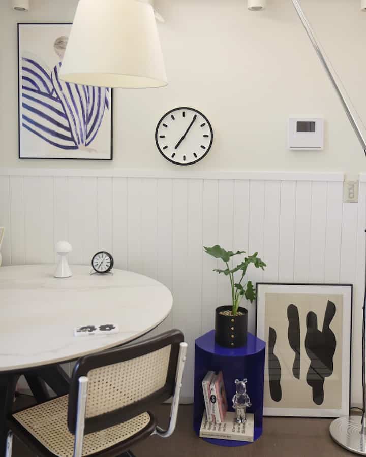 ホワイトとブラックのモノトーンのリビング、丸テーブルとブルーのサイドテーブルが配置されたシンプルモダンなインテリア