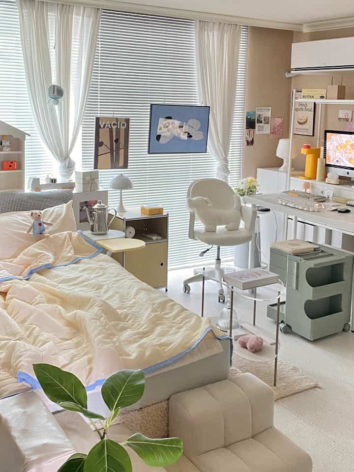 Bright white and beige bedroom and study featuring a computer desk, cozy chair, and neat modern décor