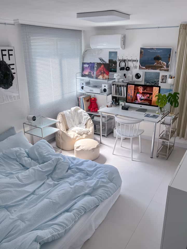 ホワイトトーンのコンパクトな寝室兼ホームオフィス、ベージュのビーズクッションと整ったデスクが配置された雰囲気のあるインテリア