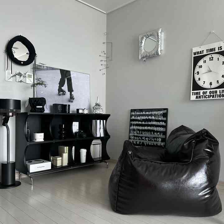 グレーの壁とブラックのビーズクッションが調和する、モダンでシンプルな1人用リビングの雰囲気のあるインテリア