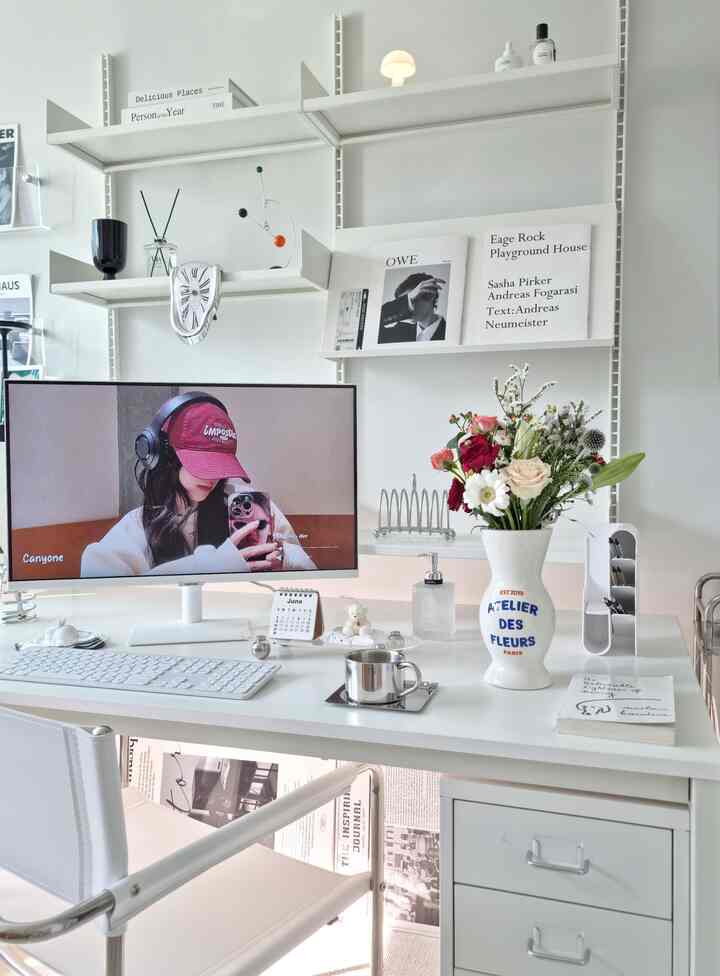 白を基調とした書斎空間、白いデスクと棚に花瓶やモビールが配置された清潔感のあるミッドセンチュリーモダンなインテリア