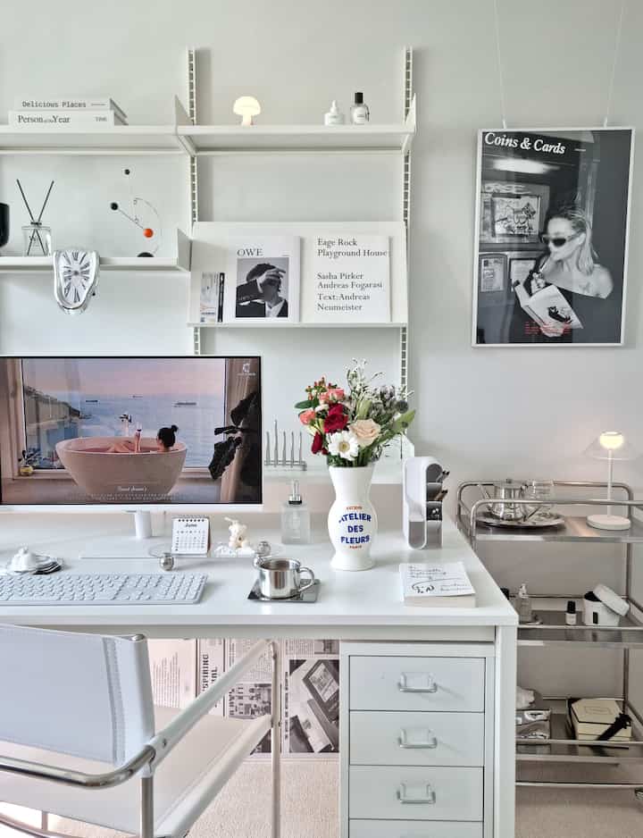 White-toned study featuring a white desk with a vintage lettering vase and modern decorative elements creating a harmonious atmosphere