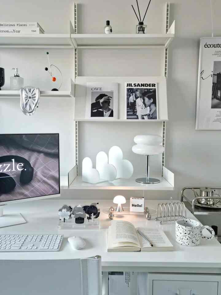 Monotone home office featuring a white desk, Mid-Century Modern lamp and neat accessories in a clean study space