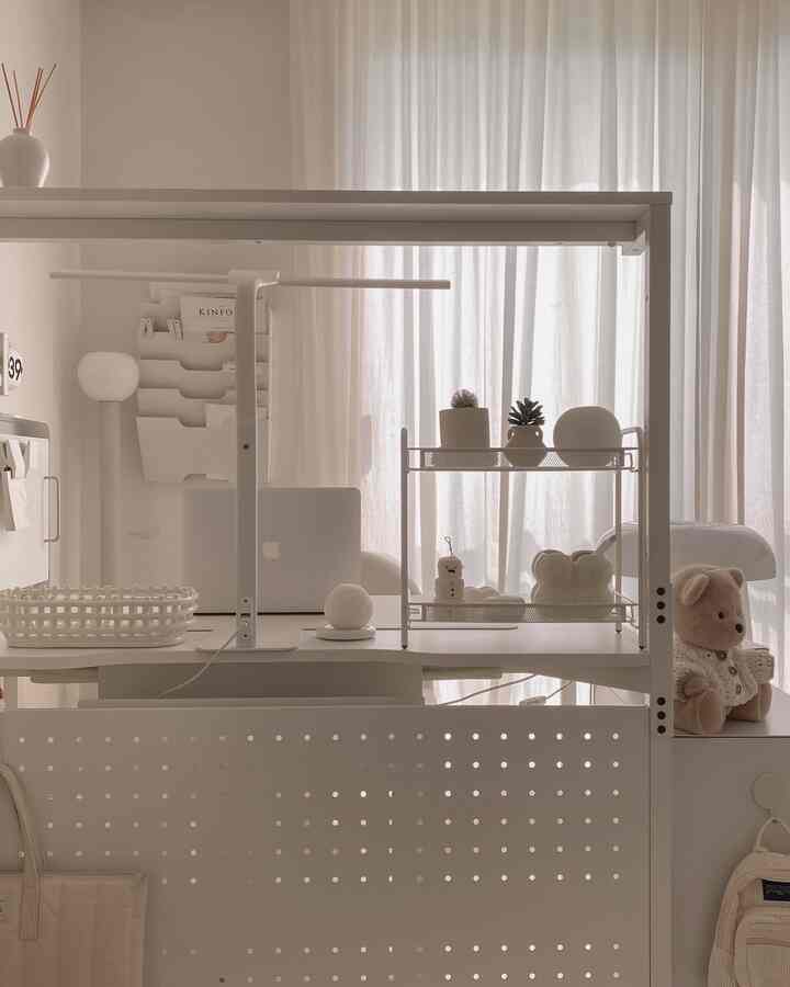 ホワイトとナチュラルトーンのホームオフィス、シンプルな雰囲気の中にデスクとディフューザーが配置された空間