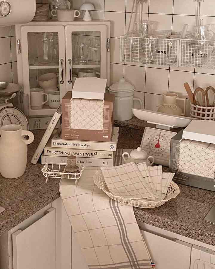 暖かみのあるブラウンとホワイトのキッチン、ヴィンテージの調理器具と収納アイデアが印象的なカウンター