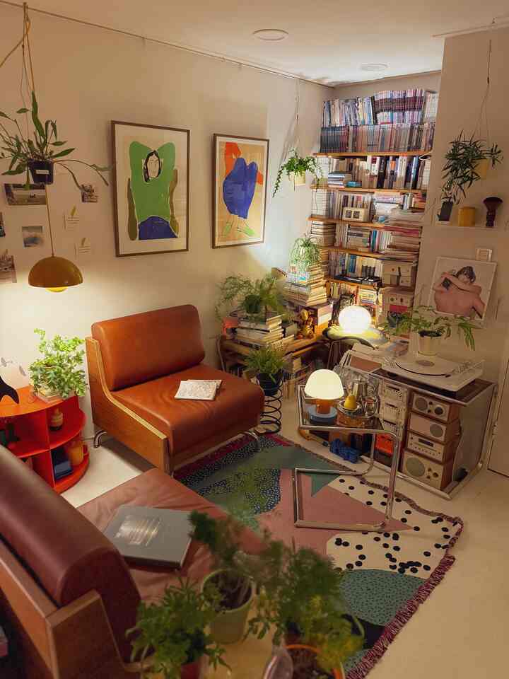 Natural-toned living room featuring brown leather sofas and various plants creating a cozy atmosphere
