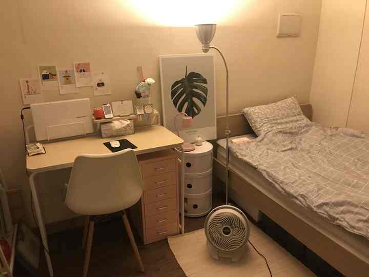 ベージュとホワイトの色調のワンルーム寝室、パソコンデスクとベッドが落ち着いた雰囲気で配置されたインテリア