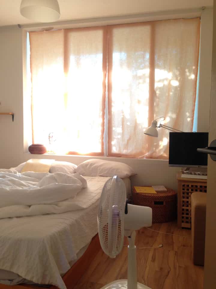 Beige-toned bedroom featuring beige curtains and white bedding in a cozy space