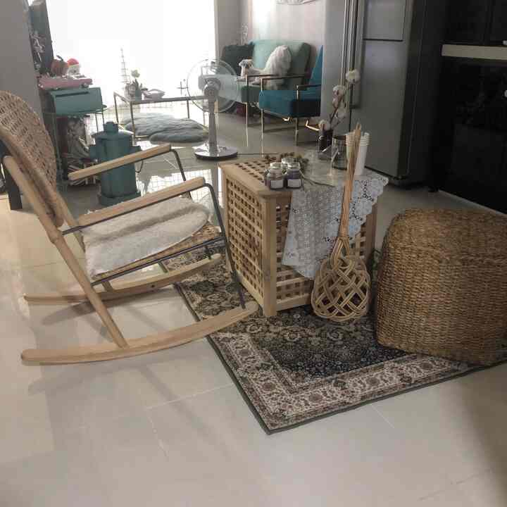 Natural wood tones and blue sofa in a living room featuring rattan decor and a Persian rug in a cozy setting