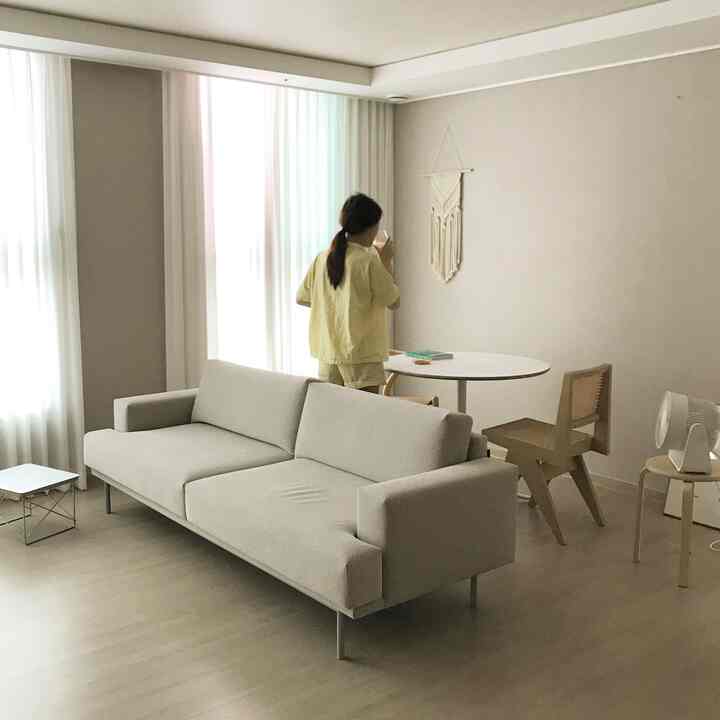 Beige and white tone living room featuring sofa and rattan armchair with a natural atmosphere