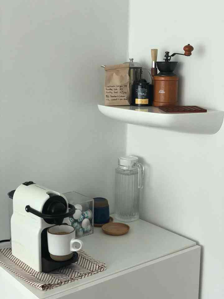 White-toned dining room corner featuring a Nespresso coffee machine and coffee accessories in a neat home cafe setup