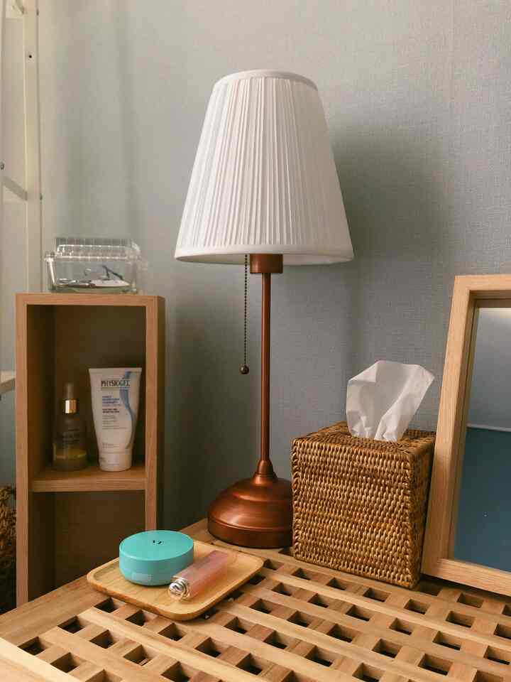 Natural wood tone bedroom featuring a table lamp and rattan tissue box creating a cozy atmosphere
