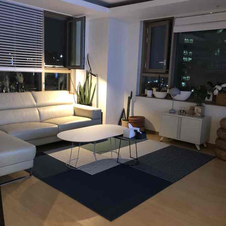 Compact natural modern living room featuring beige sofa and white coffee tables