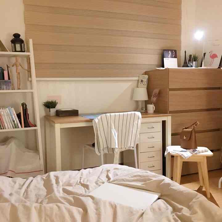 Beige and white toned studio bedroom featuring wood tone furniture and blinds, creating a cozy atmosphere