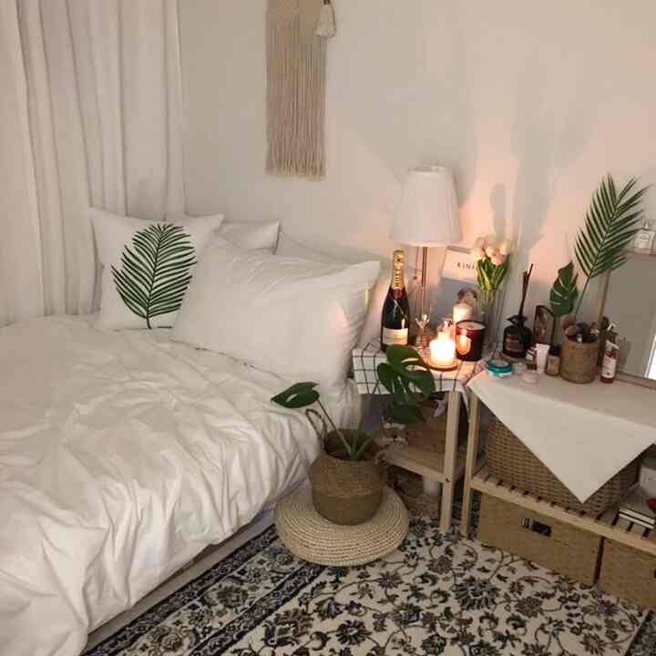 Natural-tone bedroom space featuring white mattress, wooden bed frame, nightstand, and rug creating a cozy atmosphere