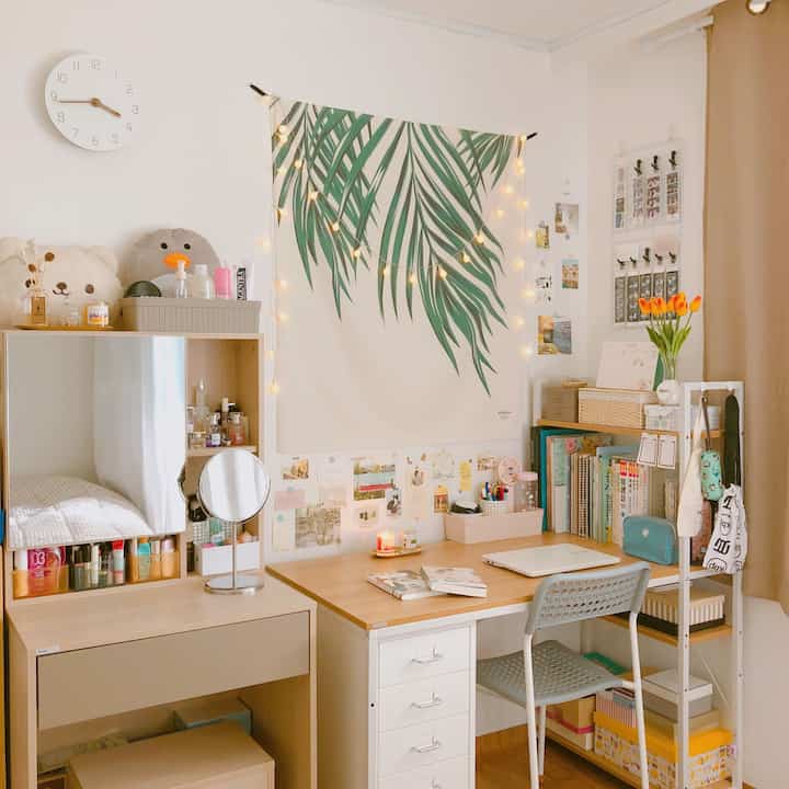 A white and beige natural-toned single occupant study space featuring a desk and bookshelf arranged neatly.