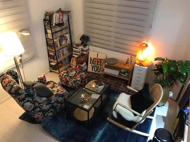A cozy living room in dark gray and natural tones featuring floor lamp and a floral patterned armchair with ambient lighting