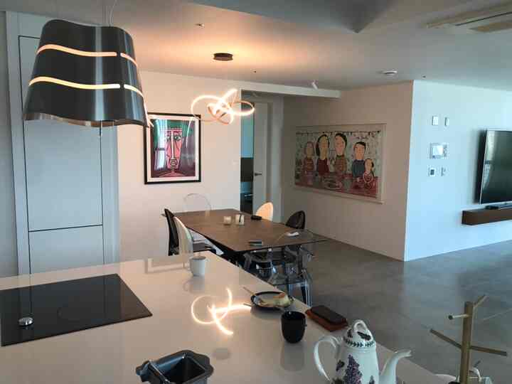 A white and natural color dining room featuring a wooden dining table and transparent chairs, creating a modern atmosphere